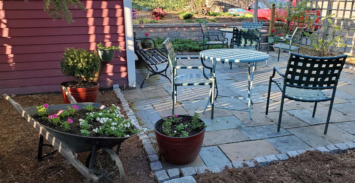 patio with bluestone pavers, antique wheelbarrow used as planter