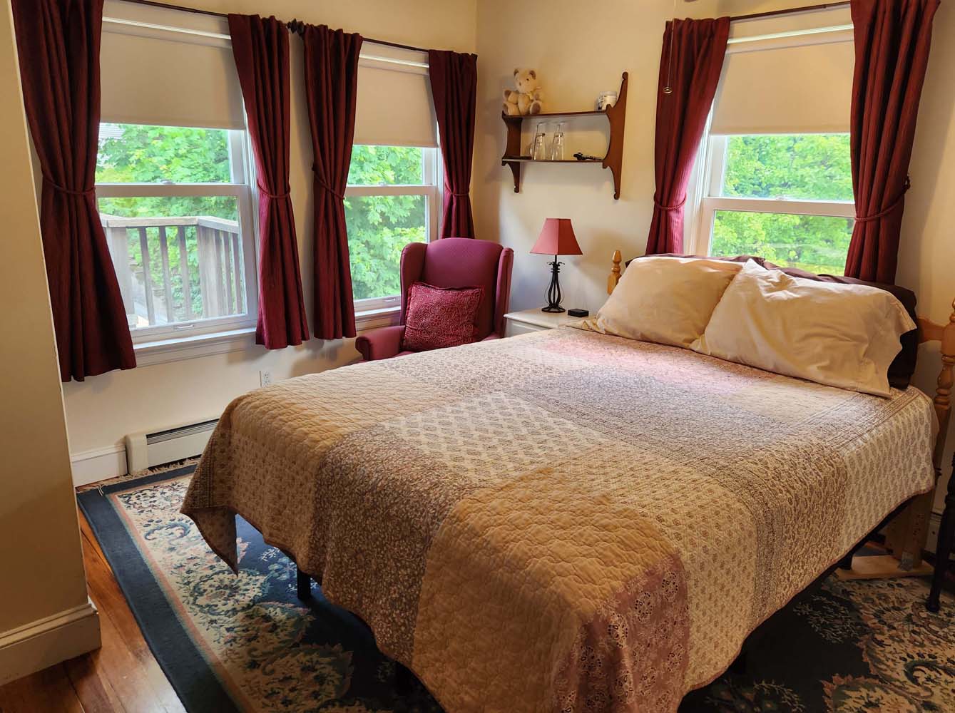 thumbnail: queen bed with quilt in room with 3 windows